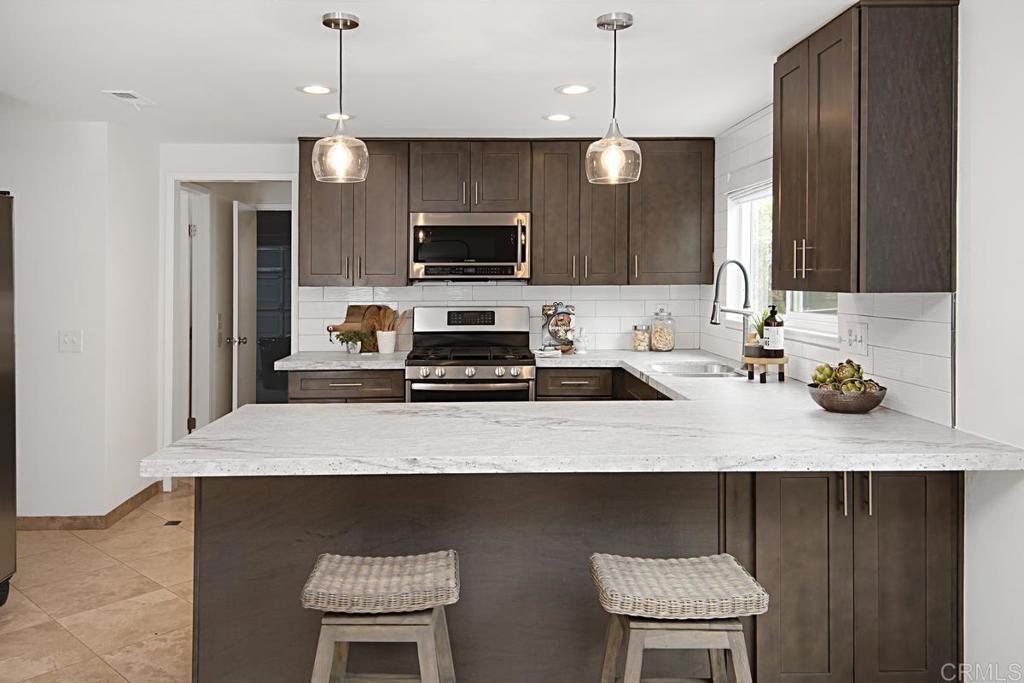 1671 James Drive Carlsbad, CA 92008 - Photo 16 of 41 a kitchen with a sink a stove and chairs