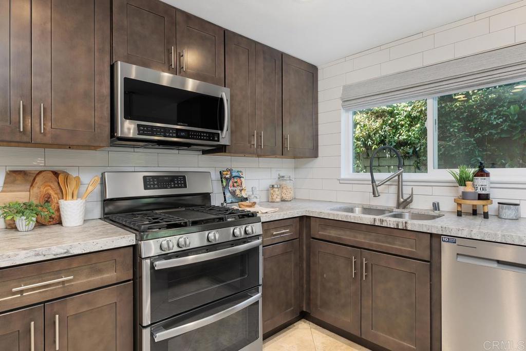 1671 James Drive Carlsbad, CA 92008 - Photo 18 of 41 a kitchen with stainless steel appliances a stove a sink a microwave and cabinets