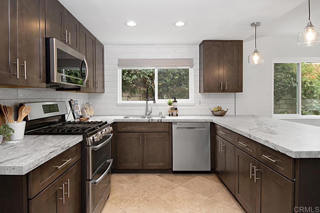 1671 James Drive Carlsbad, CA 92008 - Photo 19 of 41 a kitchen with stainless steel appliances granite countertop a sink stove and refrigerator