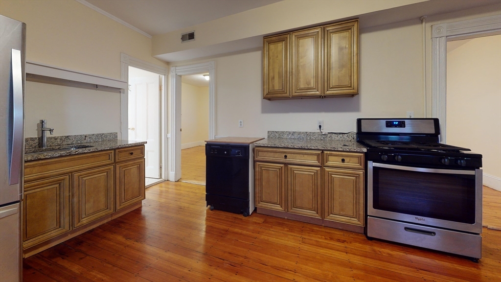 a kitchen with stainless steel appliances granite countertop a stove a sink and a microwave