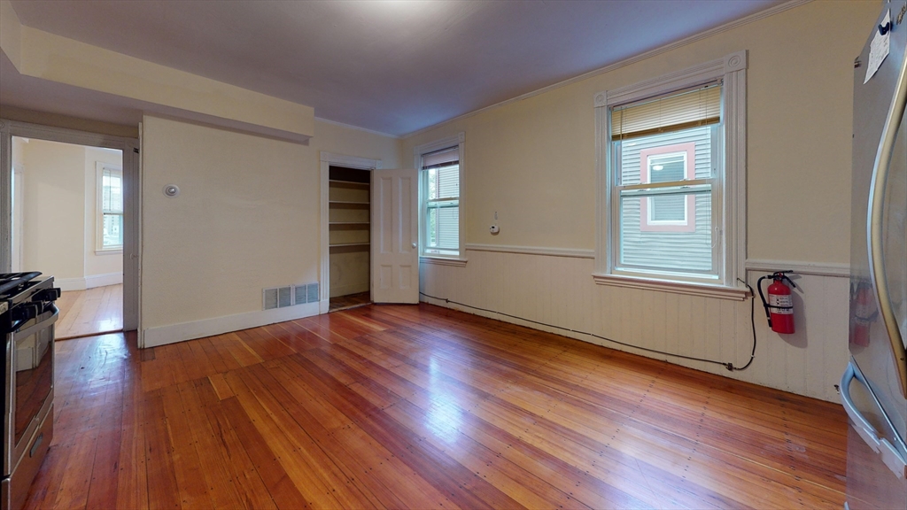 192 Hillside Street, Unit 1 Boston, MA 02120 - Photo 3 of 8 an empty room with wooden floor and windows
