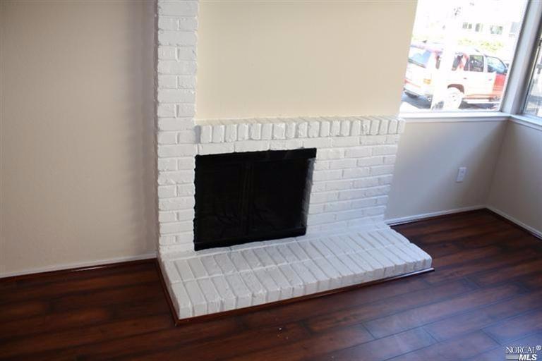 a living room with a fireplace and wooden floor