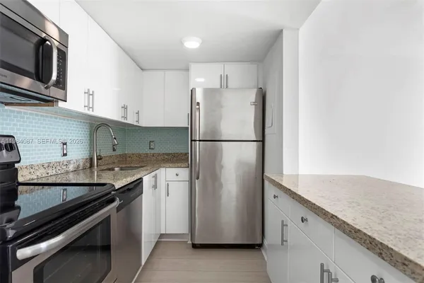 a kitchen with stainless steel appliances granite countertop a refrigerator and a sink