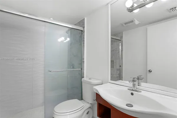 a bathroom with a sink toilet and shower