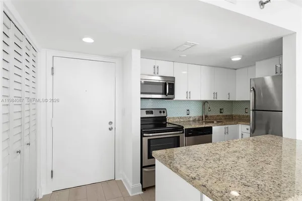 a kitchen with kitchen island a sink stainless steel appliances and cabinets