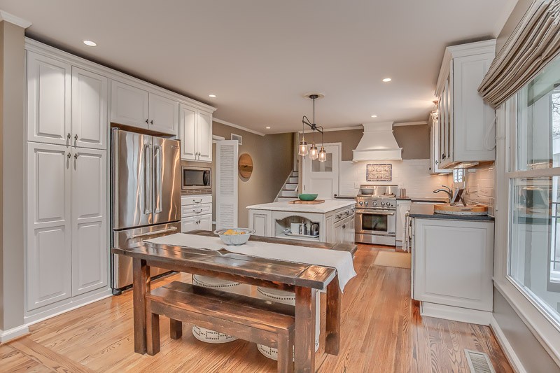 5911 Post Road Nashville, TN 37205 - Photo 11 of 38 a kitchen with stainless steel appliances kitchen island granite countertop a refrigerator a stove and white cabinets with wooden floors
