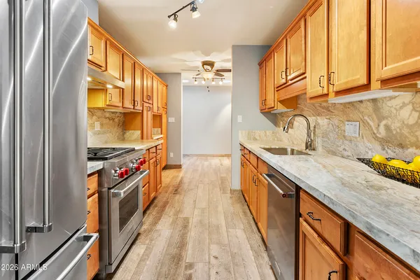 a kitchen with stainless steel appliances granite countertop a sink and a stove