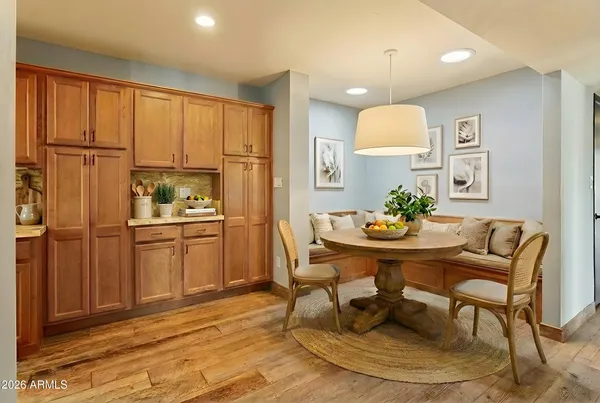 a kitchen with stainless steel appliances kitchen island granite countertop a refrigerator a stove a microwave oven with white cabinets and wooden floor