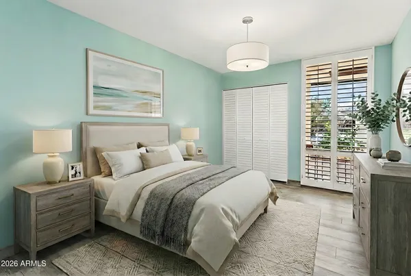 a bedroom with a bed and a lamp on dresser