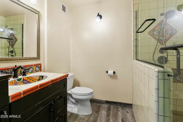 a bathroom with a granite countertop sink toilet and shower