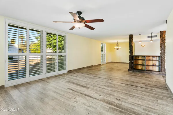 a view of empty room with wooden floor and fan