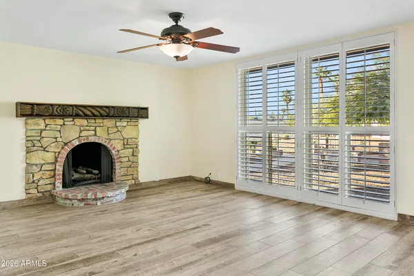 a view of empty room with wooden floor and fireplace