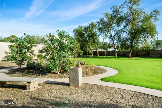 an empty room with wooden floor chandelier fan and windows