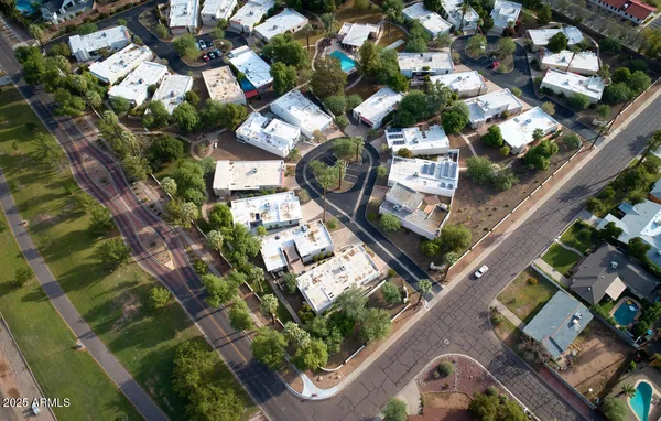 an empty room with wooden floor chandelier fan and windows