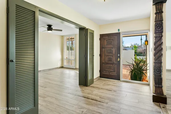 a view of a hallway with wooden floor and a potted plant