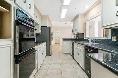 a kitchen with stainless steel appliances granite countertop a sink and a stove