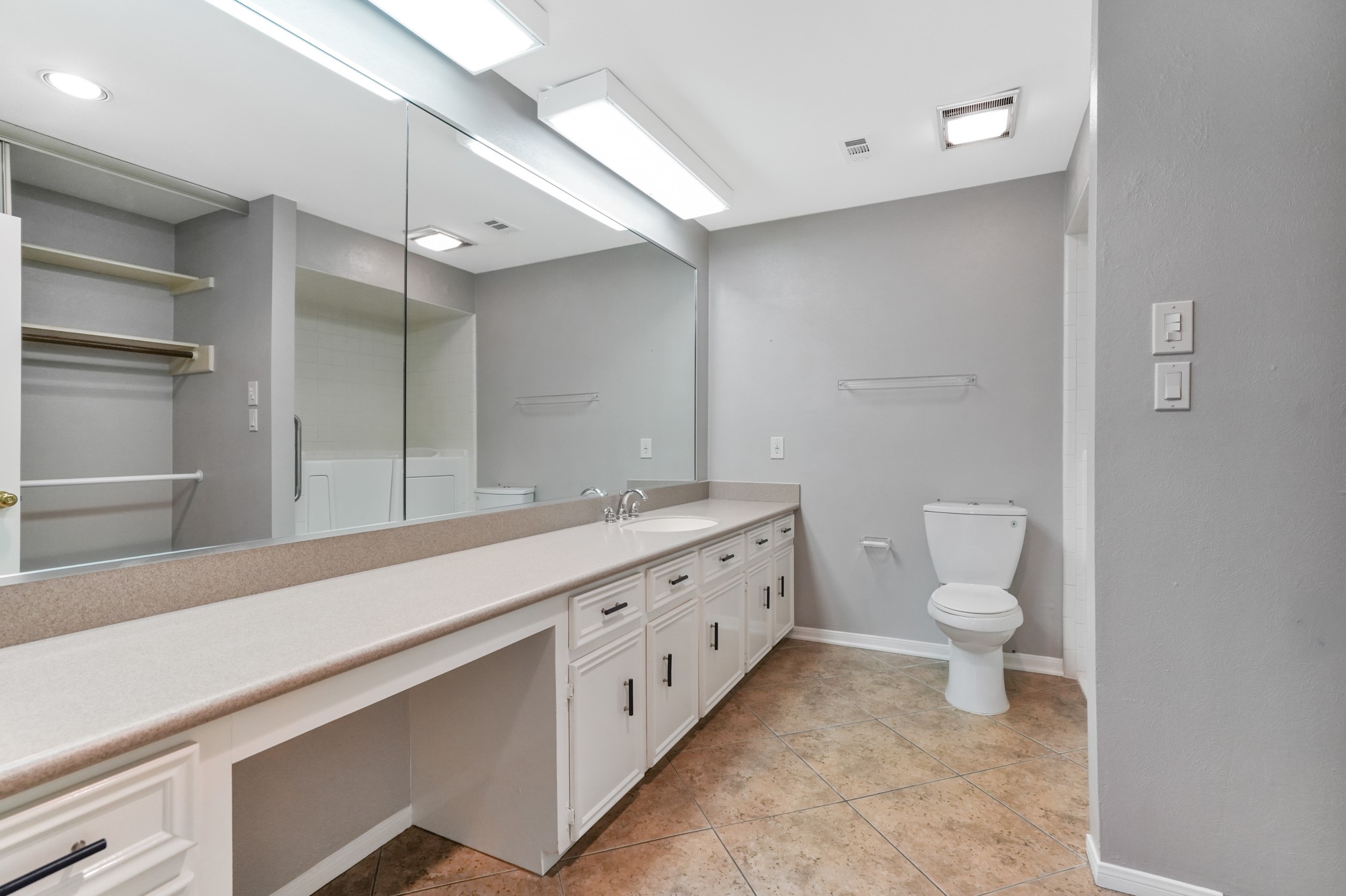201 Vanderpool Lane, Unit 65 Houston, TX 77024 - Photo 30 of 34 a spacious bathroom with a toilet a sink and a large mirror