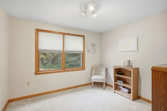 a room with a baby crib furniture a mirror and a window