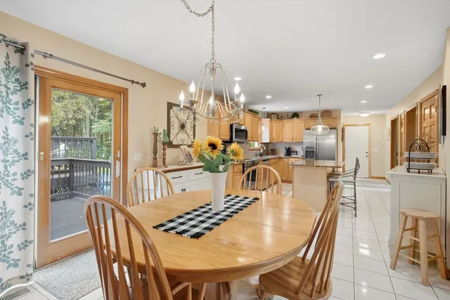 a dining room with furniture a chandelier and wooden floor