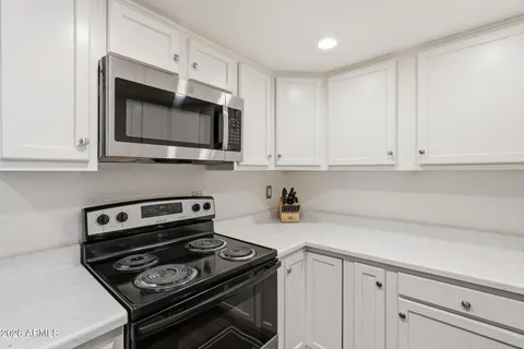 a kitchen with white cabinets and a sink