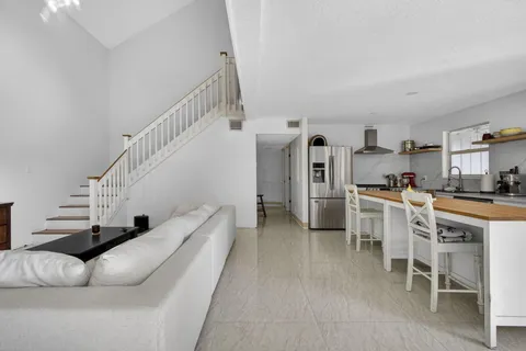 a living room with furniture and a dining table with kitchen view