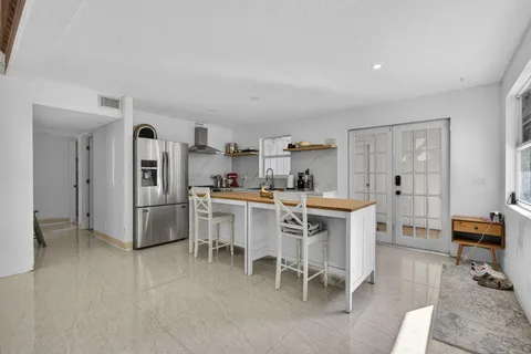 a kitchen with stainless steel appliances a refrigerator a table and chairs