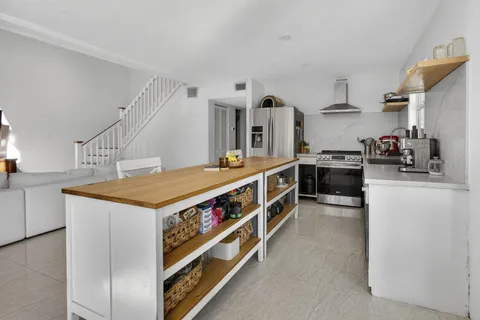 a kitchen with stainless steel appliances granite countertop a sink a stove and a refrigerator