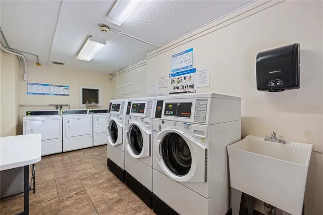 a utility room with dryer washer and stair