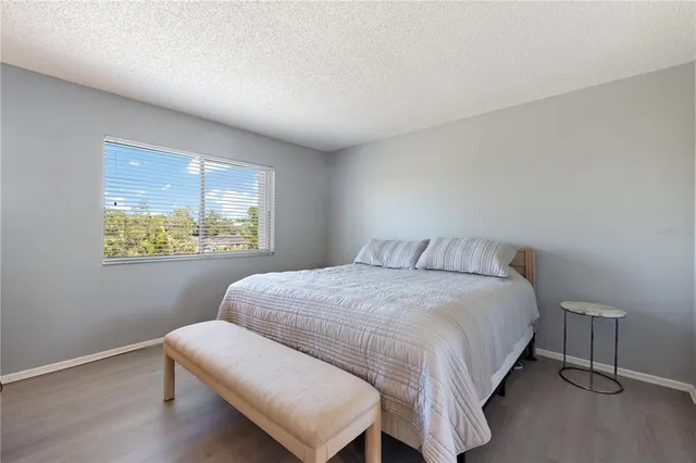 a bedroom with a bed window and a night stand