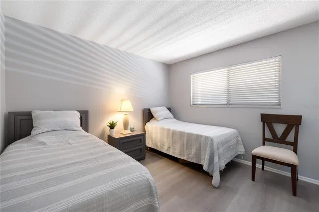 a bedroom with two beds chair and a window