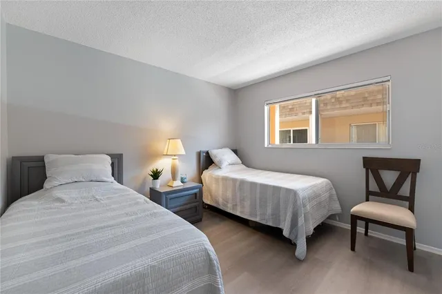 a bedroom with two beds chair and a window