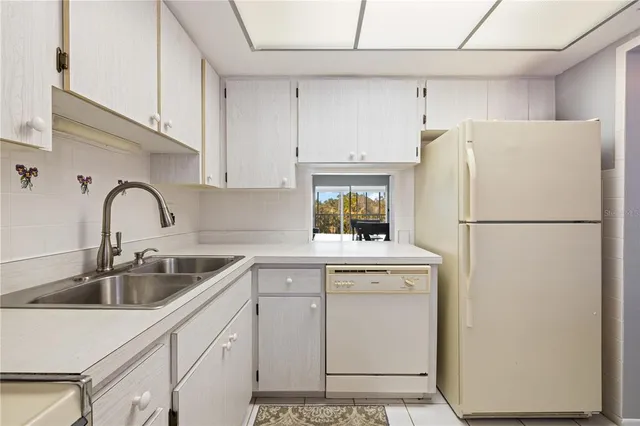 a kitchen with appliances a sink and cabinets