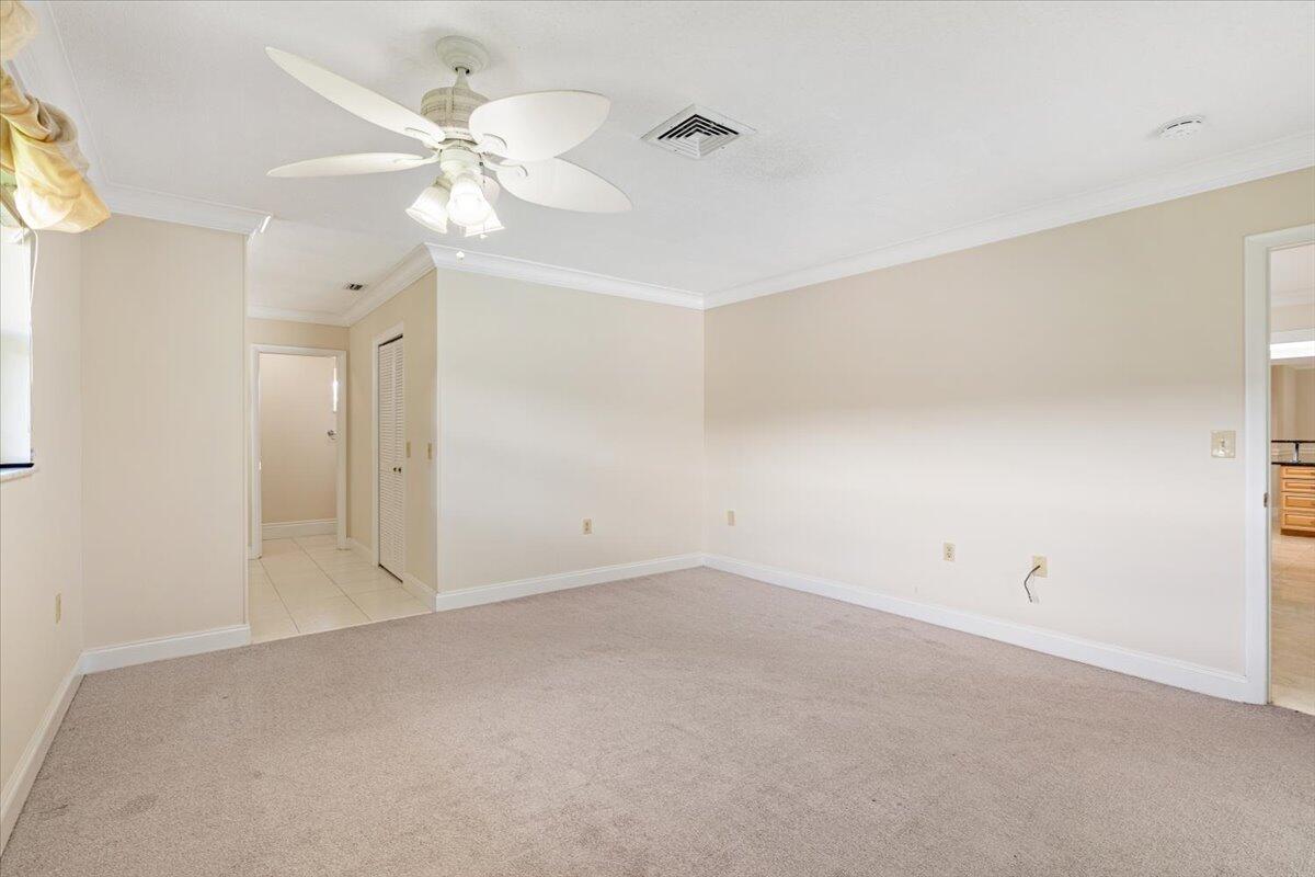 3261 Southeast Fairway West Stuart, FL 34997 - Photo 11 of 44 an empty room with a ceiling fan and a window