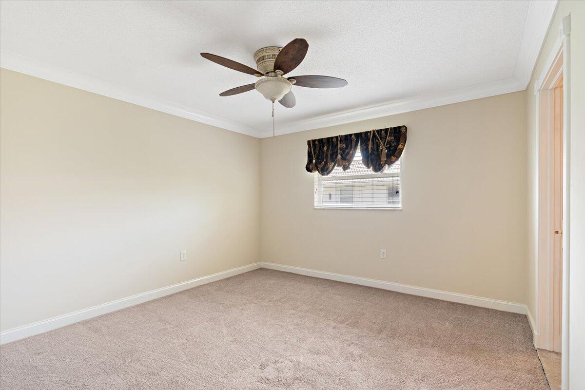 3261 Southeast Fairway West Stuart, FL 34997 - Photo 15 of 44 an empty room with windows and ceiling fan