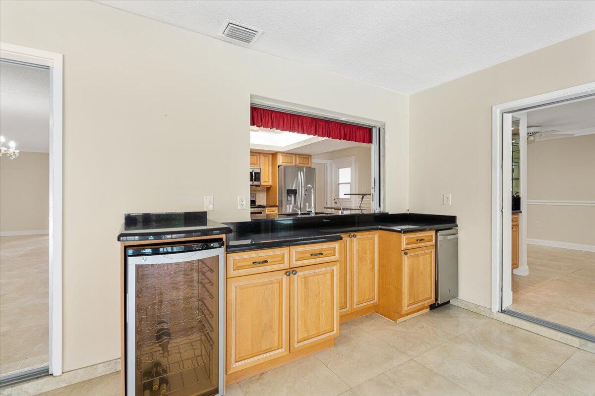 3261 Southeast Fairway West Stuart, FL 34997 - Photo 28 of 44 a kitchen with stainless steel appliances granite countertop a sink and a refrigerator