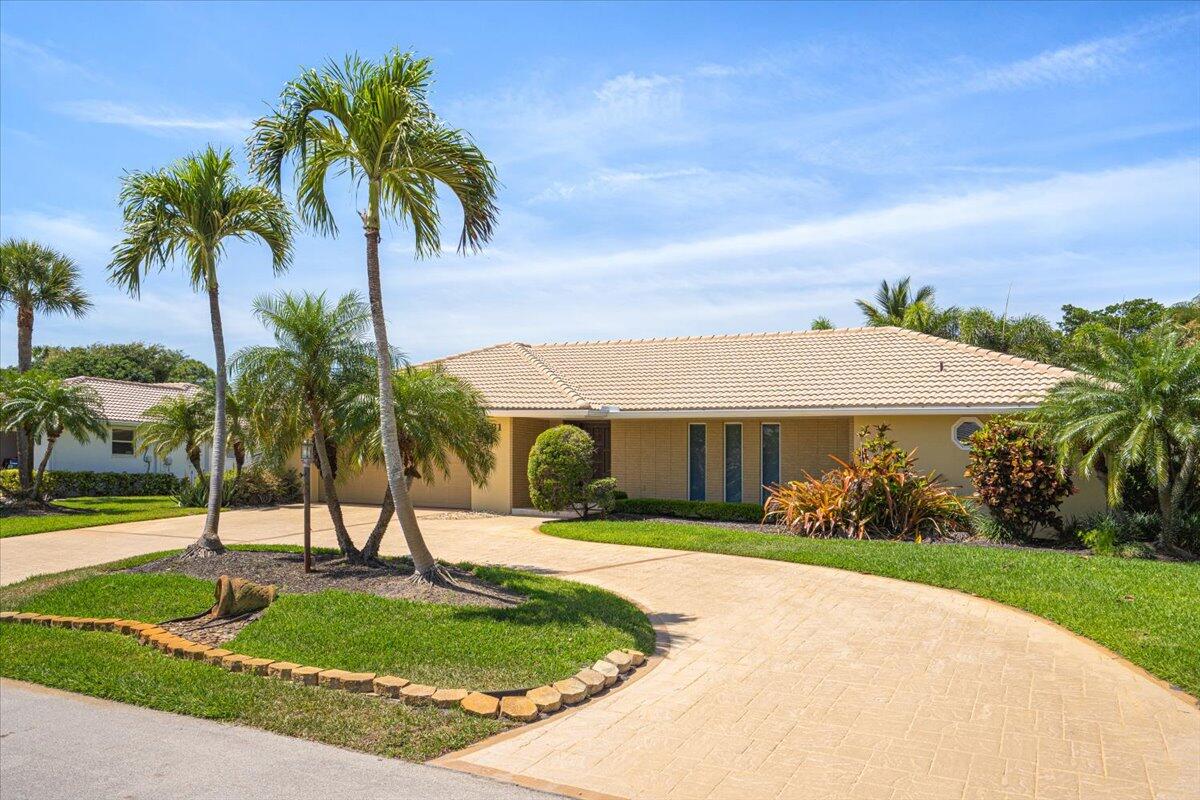 3261 Southeast Fairway West Stuart, FL 34997 - Photo 3 of 44 a view of a house with a yard and palm trees