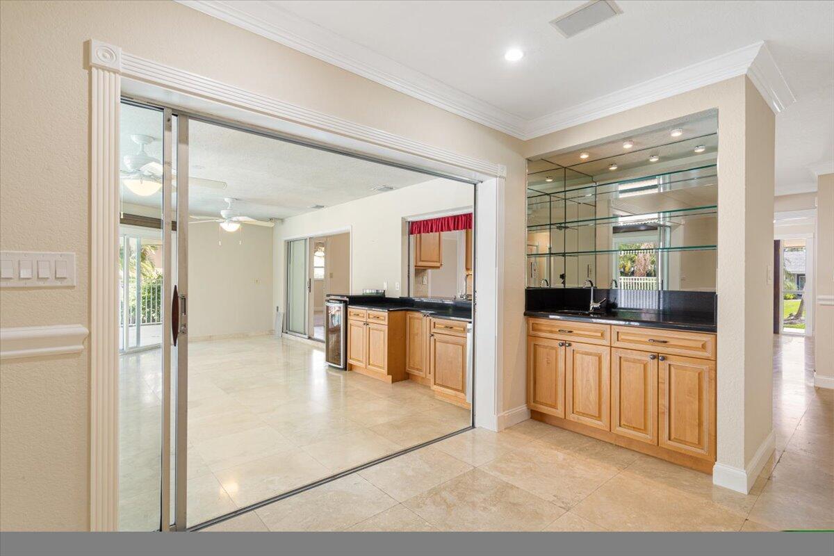 3261 Southeast Fairway West Stuart, FL 34997 - Photo 32 of 44 a kitchen with stainless steel appliances kitchen island granite countertop a refrigerator and a sink