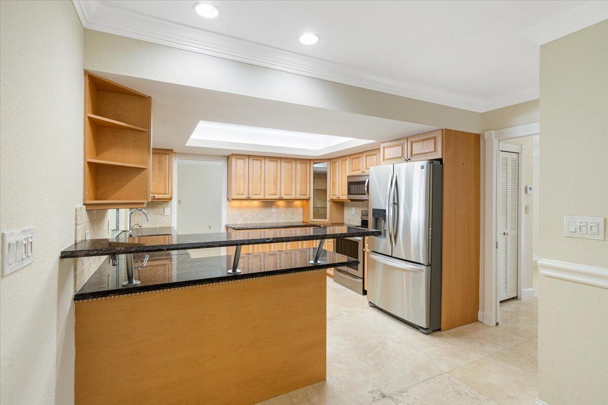 3261 Southeast Fairway West Stuart, FL 34997 - Photo 35 of 44 a kitchen with stainless steel appliances a refrigerator and a window