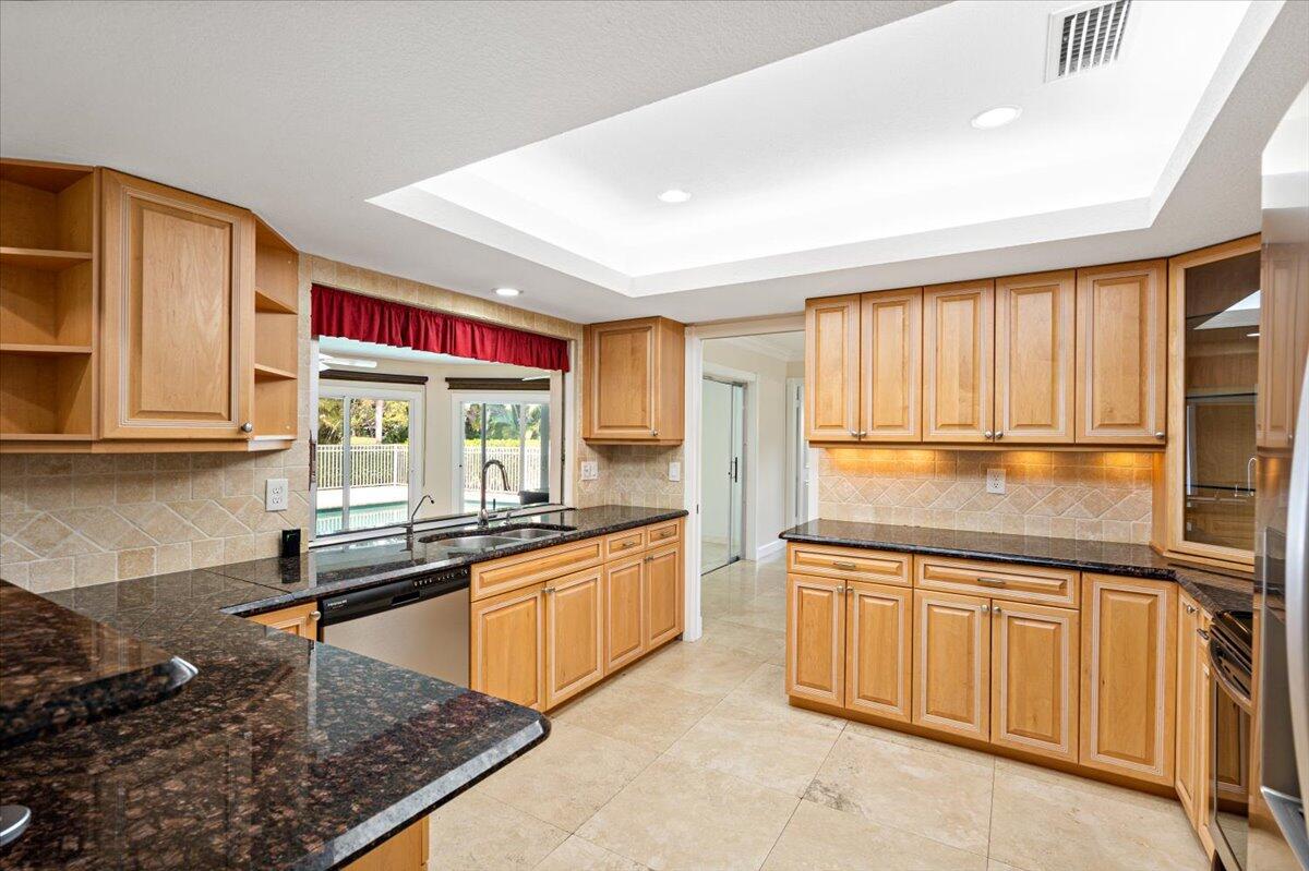 3261 Southeast Fairway West Stuart, FL 34997 - Photo 36 of 44 a kitchen with stainless steel appliances granite countertop a stove a sink and a microwave