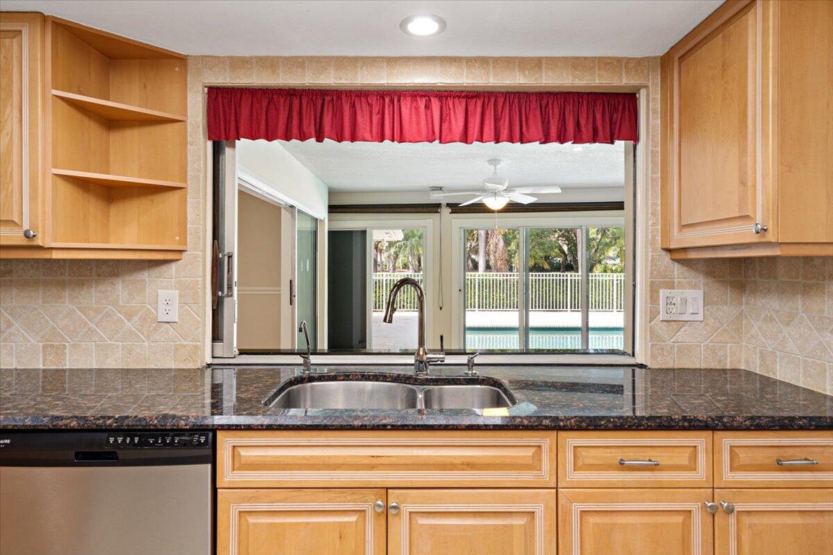 3261 Southeast Fairway West Stuart, FL 34997 - Photo 37 of 44 a kitchen with kitchen island granite countertop a sink and a window