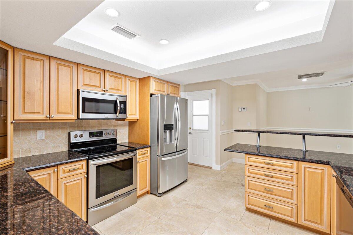3261 Southeast Fairway West Stuart, FL 34997 - Photo 38 of 44 a kitchen with stainless steel appliances granite countertop a refrigerator and a stove top oven