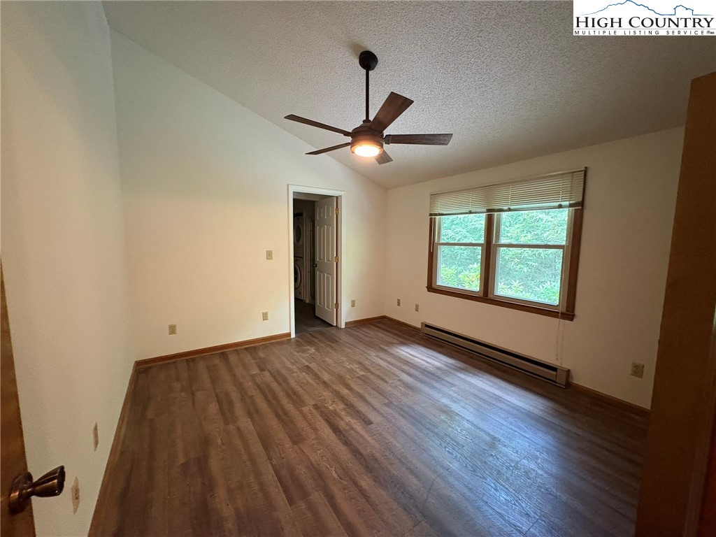 527 Windridge Road Newland, NC 28657 - Photo 14 of 33 an empty room with wooden floor chandelier fan and windows