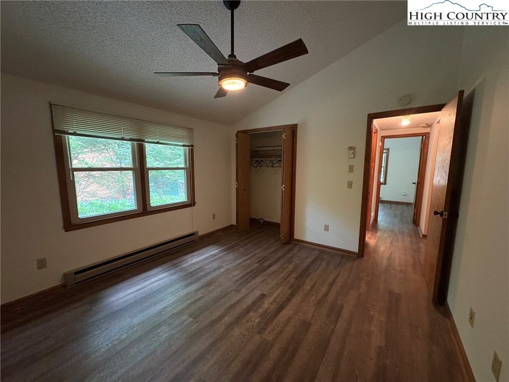 527 Windridge Road Newland, NC 28657 - Photo 15 of 33 an empty room with wooden floor chandelier fan and windows