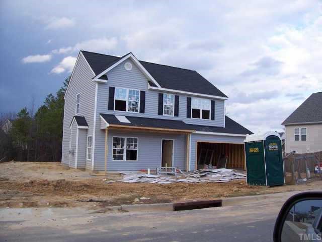a front view of a house with yard and tress