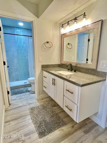 a bathroom with a granite countertop sink and a mirror