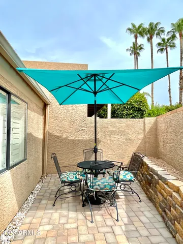 a view of a patio with chairs under an umbrella