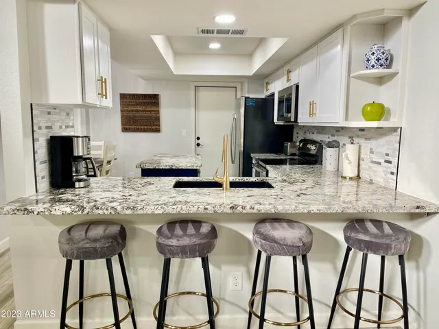 a kitchen with stainless steel appliances granite countertop a stove a sink and a refrigerator