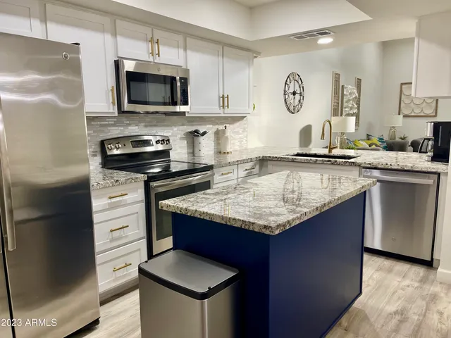 a kitchen with stainless steel appliances granite countertop a sink stove and refrigerator