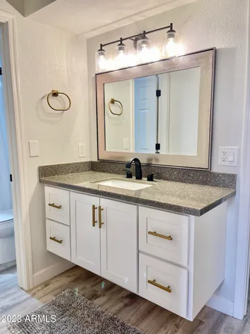 a bathroom with a granite countertop sink and a mirror