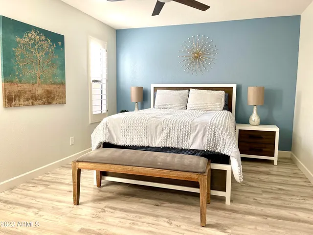 a bedroom with a bed a rug and wooden floor